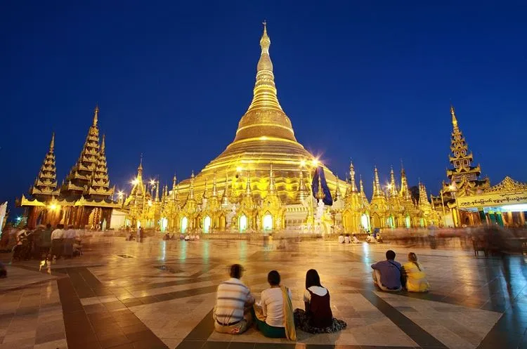 Shwedagon Pagoda under the soft light of dusk, with its radiant gold stupa towering majestically over Yangon.